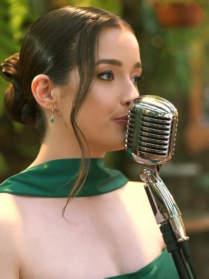 Jamilli cantando ao microfone vintage em recepção ao ar livre